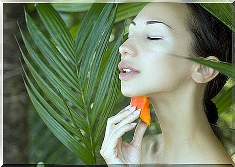 woman putting papaya on her skin