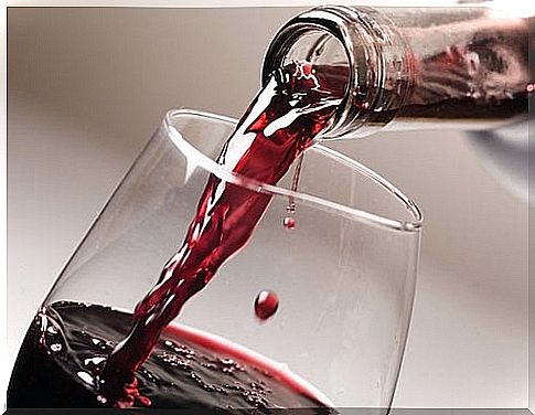 The red wine is poured into a glass